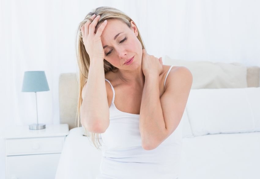 Woman experiencing neck pain and headache symptoms associated with cervicogenic headache.