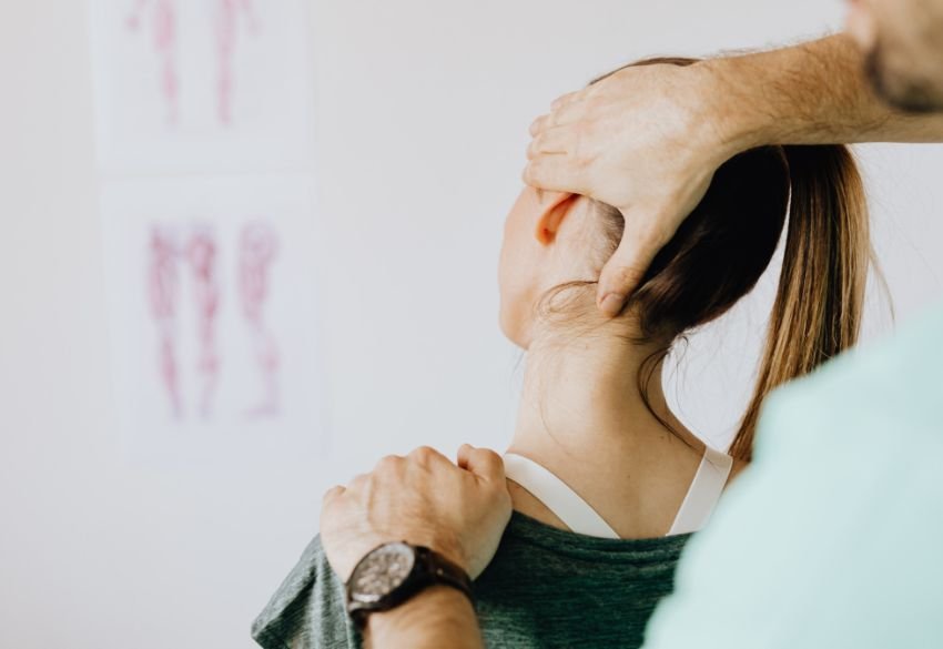 Physiotherapist performing manual therapy on a patient's neck to treat cervicogenic headache symptoms.