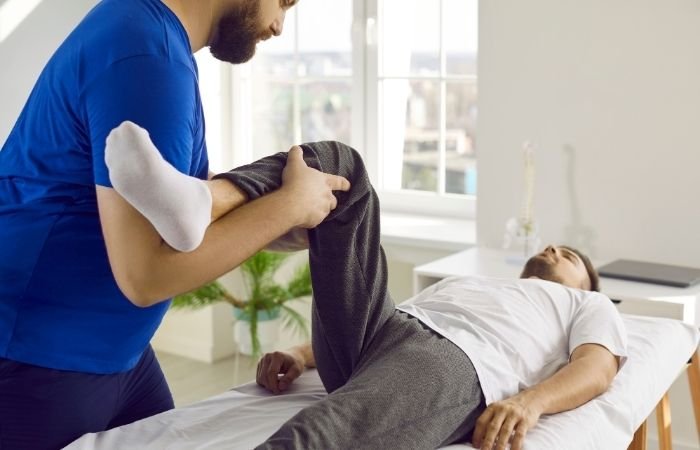 Physiotherapist assessing hip and leg movement as part of sciatica treatment in Mickleham